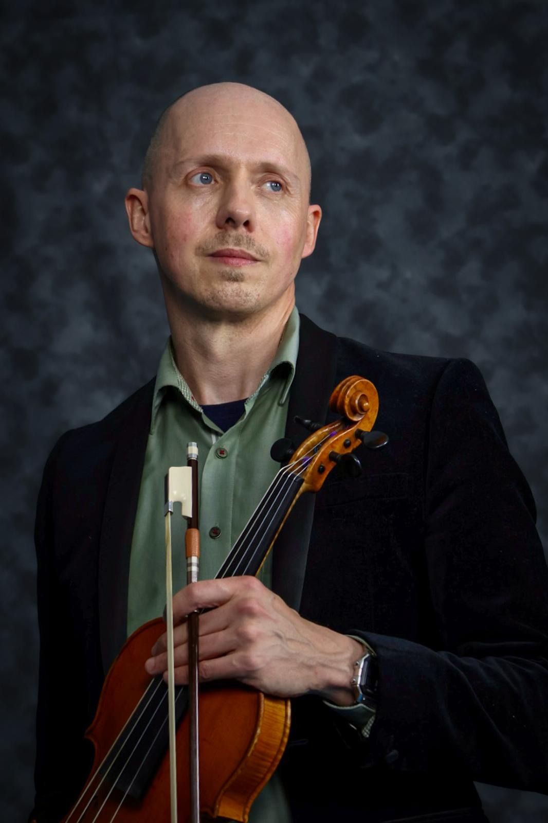 Benjamin Errington holding his viola and bow