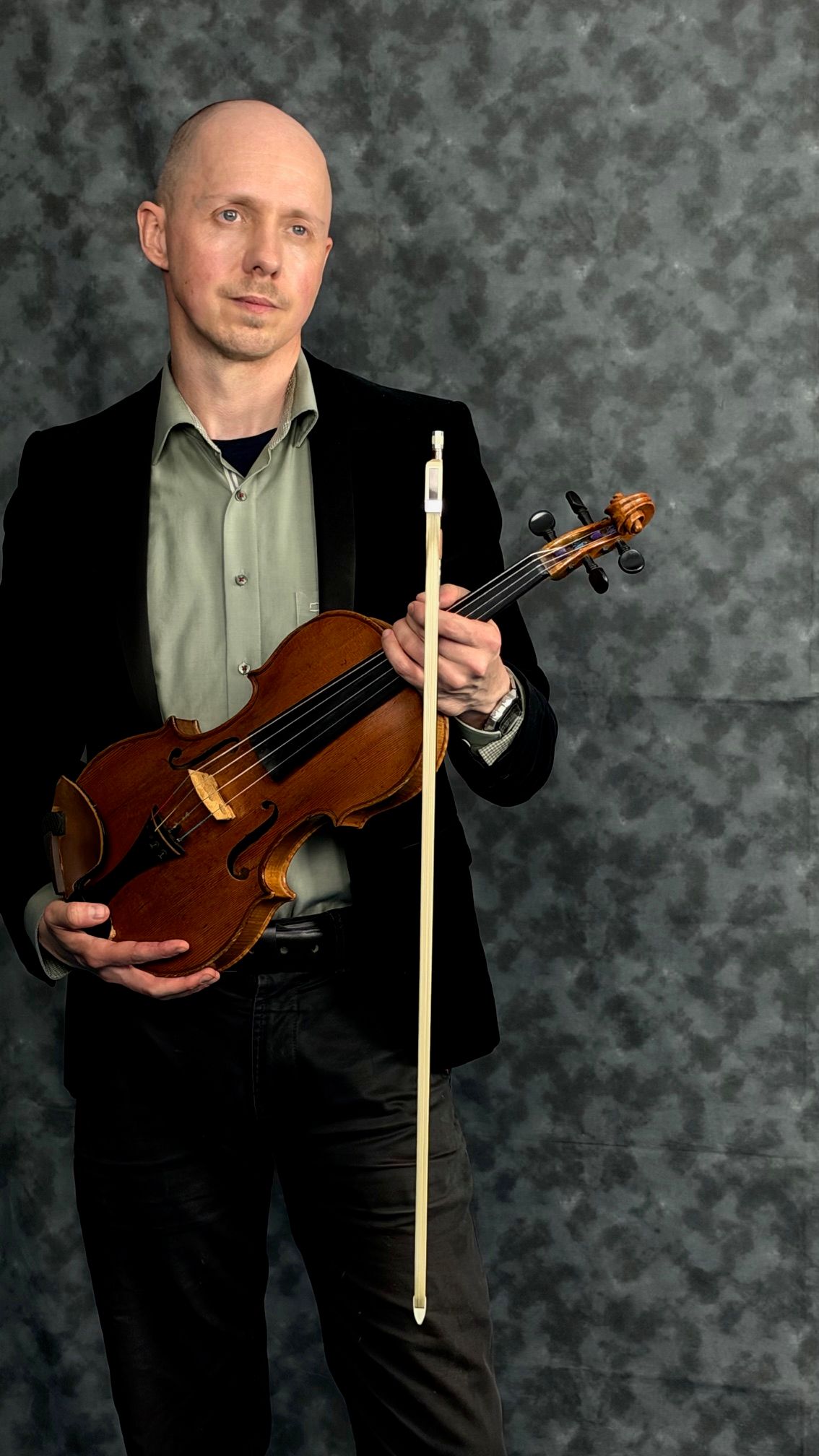 Benjamin Errington standing with his viola and bow